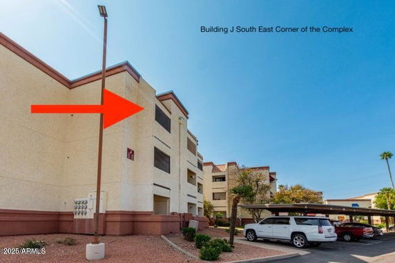 Front view of a multi-story apartment building with covered parking.