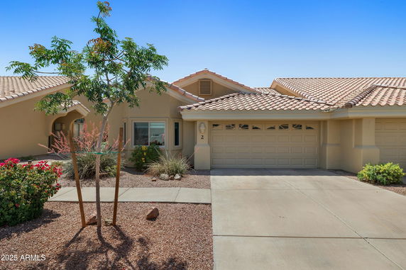 Front view of a house with a double garage and tiled roof.