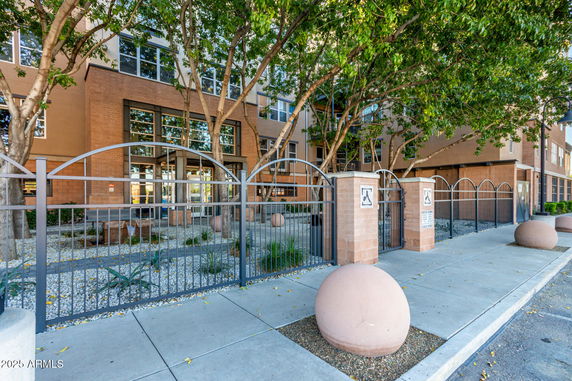 Front view of a multi-story building with a gated entrance.