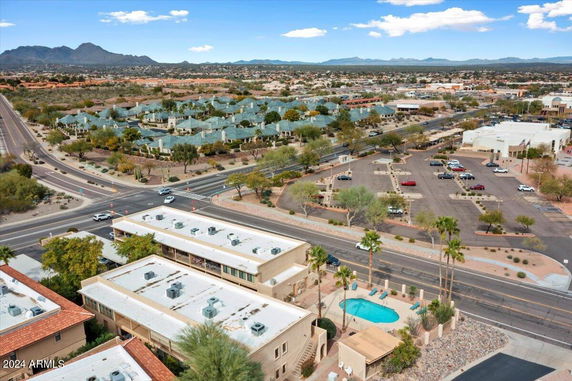 Aerial view of a suburban area with roads, buildings, and surrounding landscape.