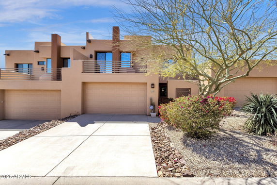 Front view of a modern two-story house with a double garage and a flat roof design.