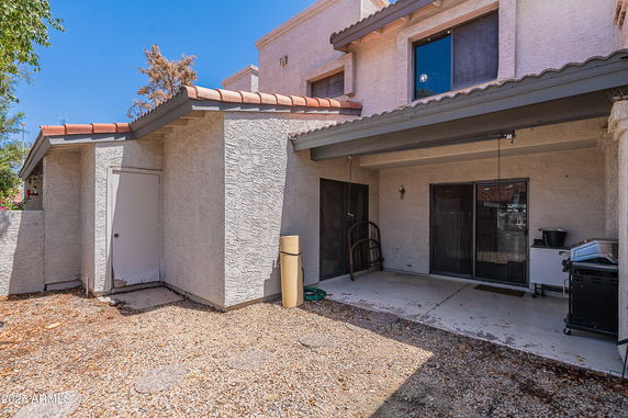 Rear view of a two-story house with a covered patio area.
