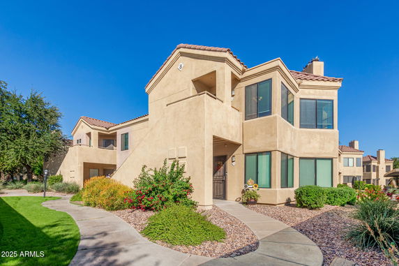 Front view of a two-story house with stucco exterior and tile roof.