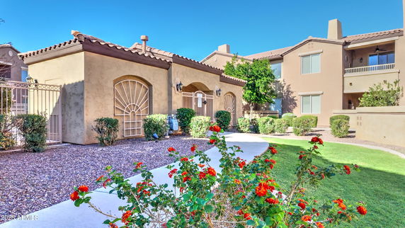 Front view of a single-story building with arched windows and a tiled roof.