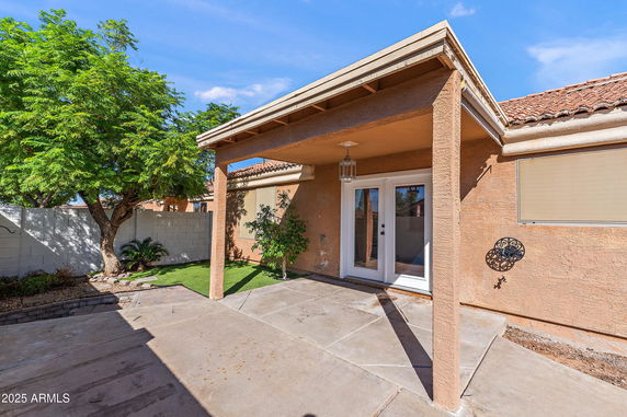 Front view of a single-story house with a covered porch and double doors.