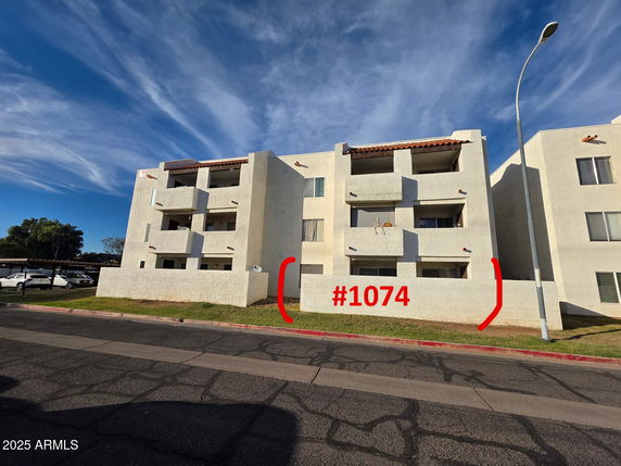 Front view of a multi-story apartment building with balconies.