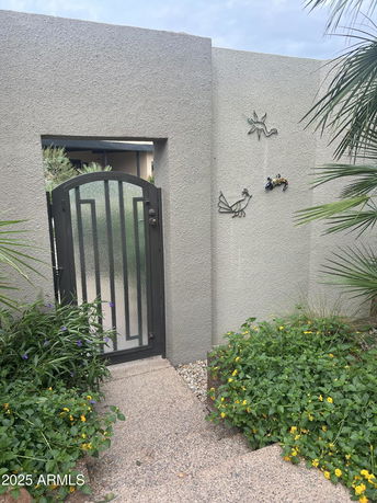 Front view of a garden gate with decorative wall.