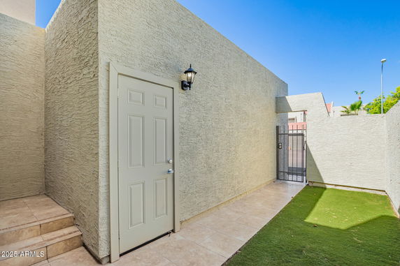 Side view of a building exterior with a door and a gated entrance.