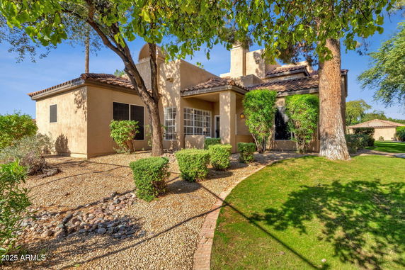 Front view of a house with stucco exterior and sloped roof.