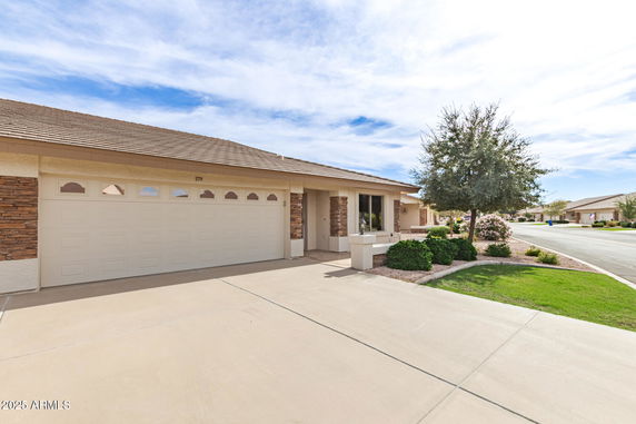 Front view of a single-story house with a double garage and a landscaped front yard.