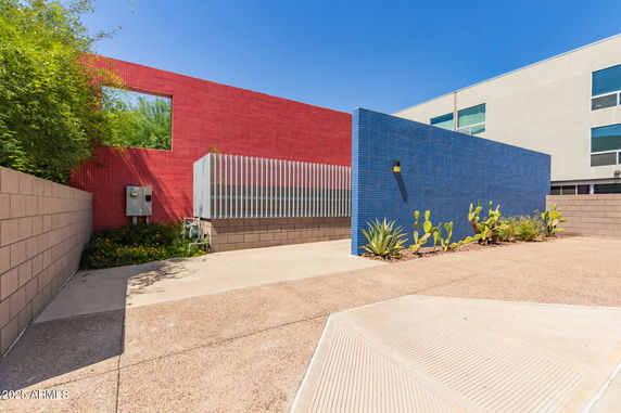 Front view of a building with red and blue tiled walls.