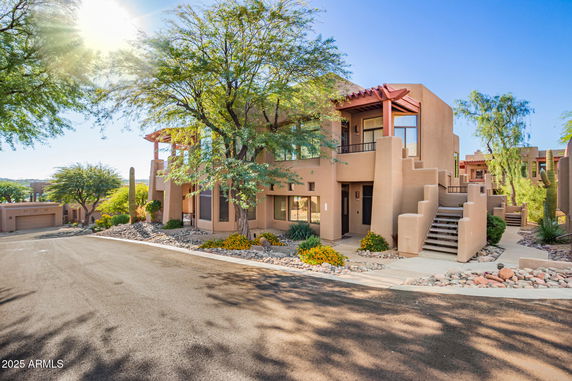 Front view of a modern two-story building with desert landscaping.