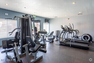 Indoor gym area with exercise machines and equipment.