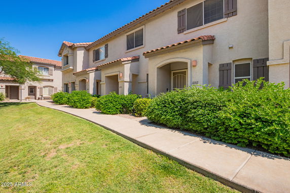 Front view of a two-story building with multiple units and a walkway.