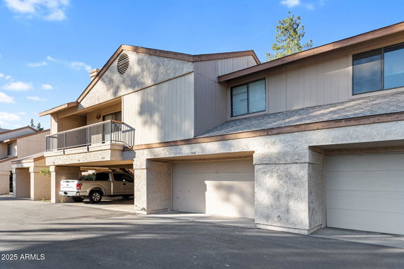 Front view of a two-story house with a garage and balcony.