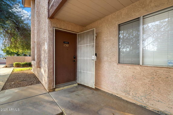Entrance view of a building with a brown door and window.