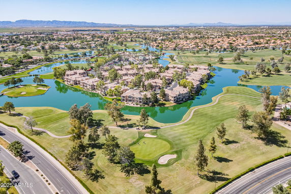 Aerial view of a neighborhood surrounded by water bodies and golf courses.