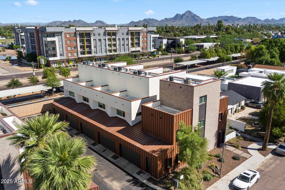 Aerial view of a modern multi-story building with a brown and white facade.