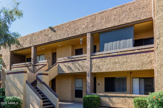 Front view of a two-story building with exterior staircases and balconies.