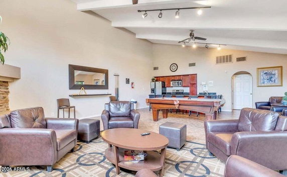 Interior of a club house featuring a pool table and leather seating.