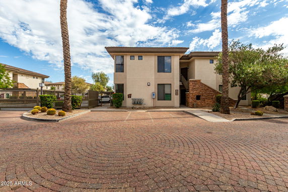 Front view of a two-story building with brick accents and gated entrance.