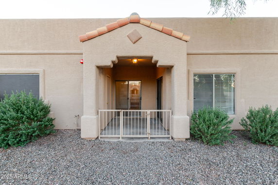 Front view of a single-story building with a covered porch and a gated entrance.
