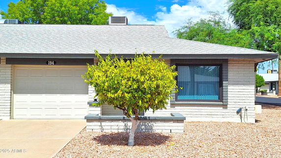 Front view of a single-story house with a garage and a small front yard.