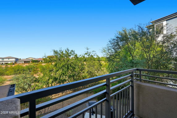 View from a balcony looking out over trees and neighboring houses.