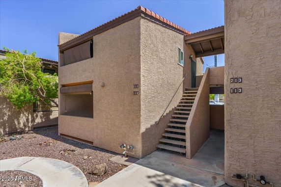 Front view of a two-story residential building with exterior stairs.