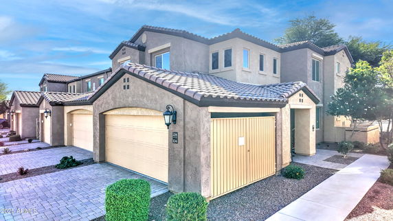 Front view of a two-story house with a tiled roof and garage.