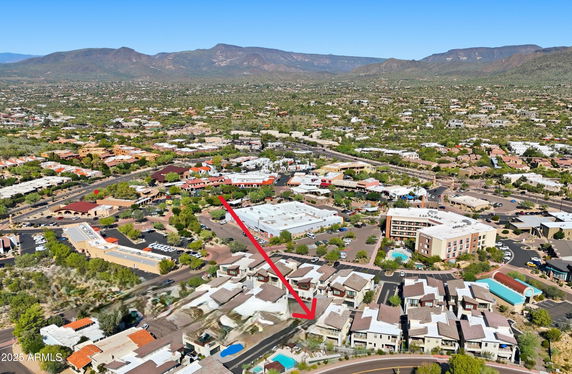 Panoramic view of a suburban area with buildings and mountains in the background.