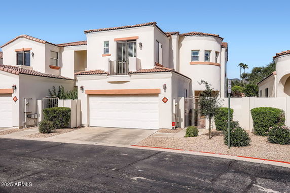 Front view of a two-story house with white walls and a double garage.
