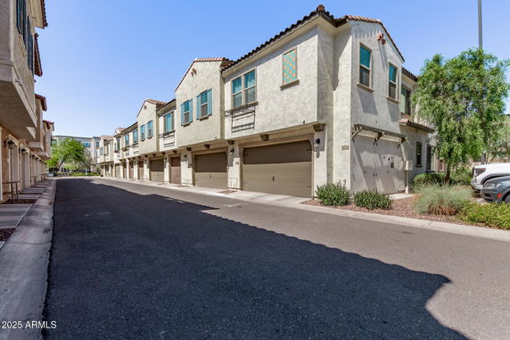 Front view of townhouses with garages on the ground level.