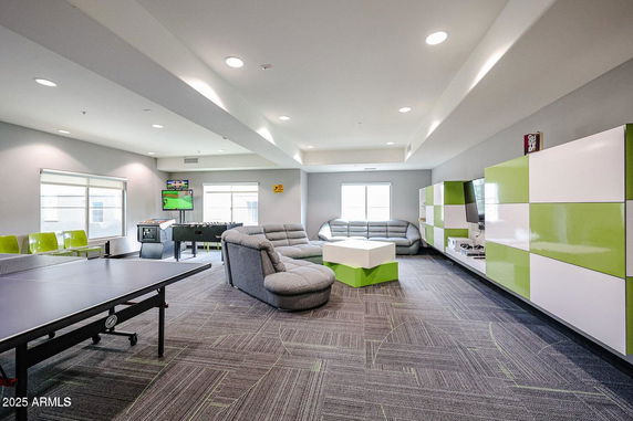 Spacious indoor recreation area with sofas, table tennis, and entertainment units.