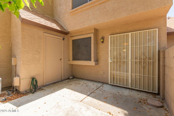Outdoor view of a corner section of a house with a door and gated window.