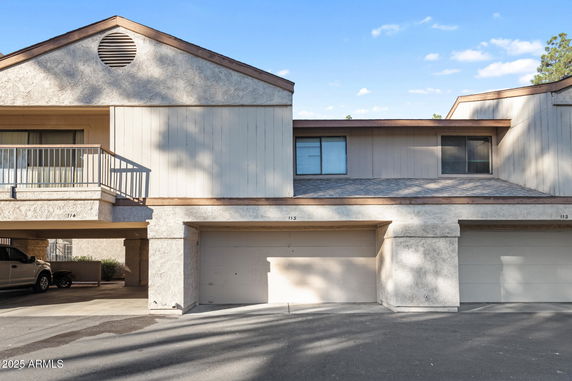 Front view of a multi-story residential building with attached garages.