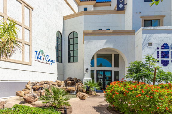 Front view of a building with arched entrance and decorative stone water feature.