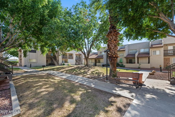 Outdoor view of a residential area with multi-story buildings and surrounding trees.