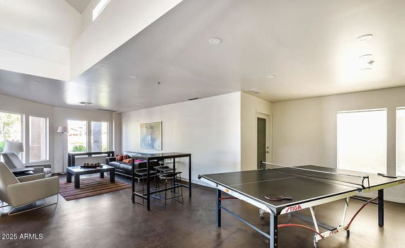 Indoor recreation area with seating and a table tennis setup.