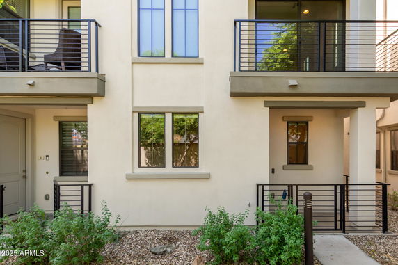 Front view of a multi-story residential building with balconies and modern design.
