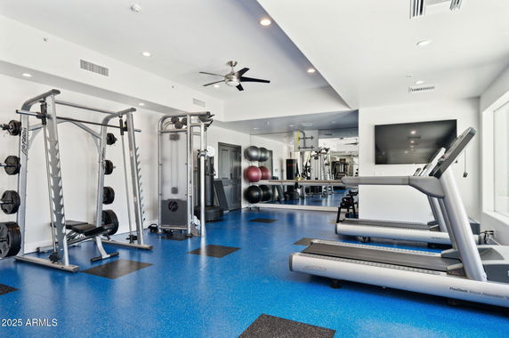 Indoor gym area with exercise equipment and blue flooring.