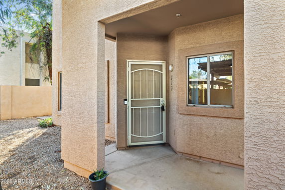 Front entrance view of a house with a metal security door and adjacent window.