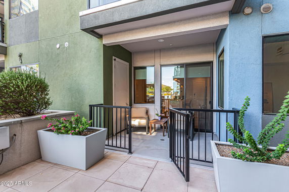 Front view of a building entrance with a small patio area and planter boxes.