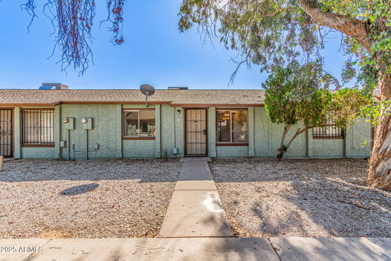Front view of a single-story house with a pathway leading to the entrance.