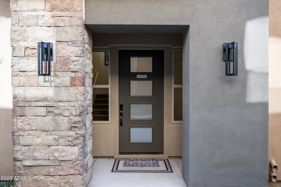 Front view of a house entrance with a modern door and stone wall accents.