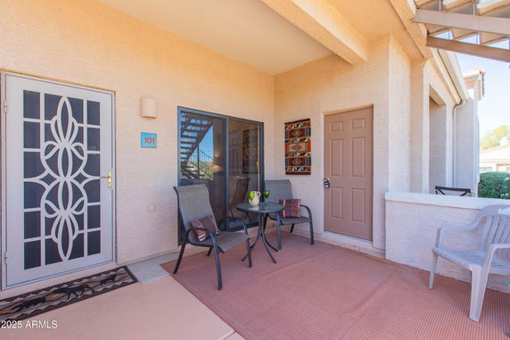 Front view of a house with a small patio and seating area.