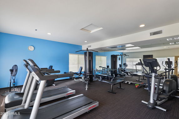 Indoor gym with fitness equipment including treadmills and resistance machines.