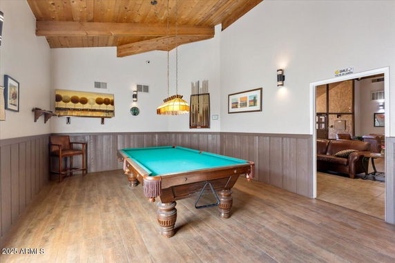Room with a billiards table and wooden ceiling, part of a club house.