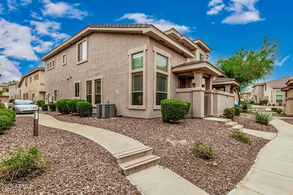 Front view of a two-story house with a pathway leading to the entrance.