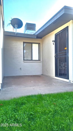 Front view of a house with a door and window, featuring a satellite dish and cooling unit on the roof.